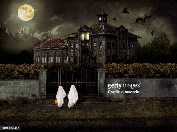 children in ghost costumes trick or treat at haunted house - spooky stock pictures, royalty-free photos & images