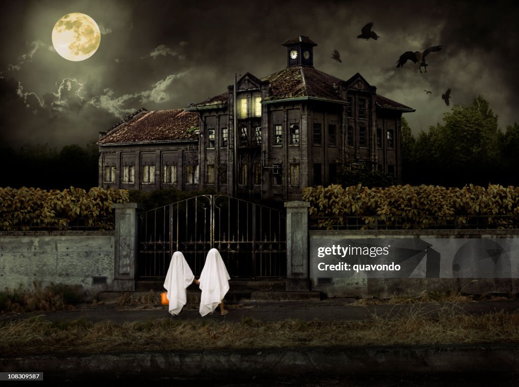 As crianças em fantasias Gostosuras ou travessuras (Trick or Treat fantasma na Haunted House