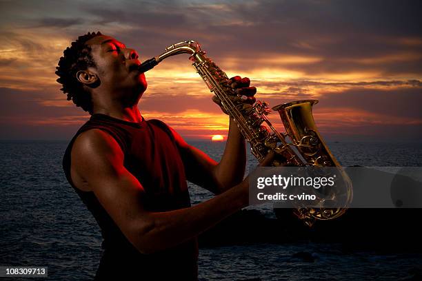 saxophonist at sunset - saxofoon stockfoto's en -beelden