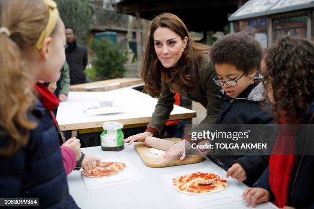 Britain's Catherine, Duchess of Cambridge helps make pizza as she visits the Islington community garden in north London on January 15, 2019.