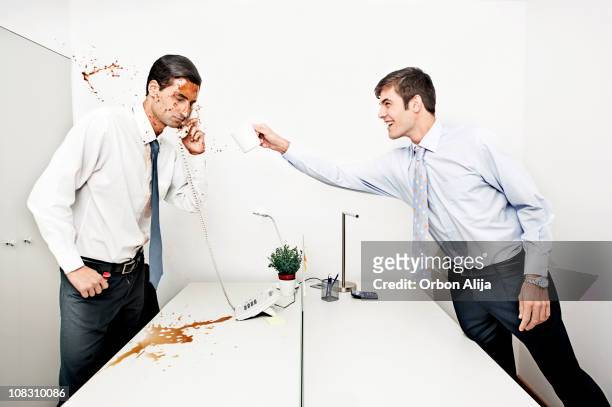 businessman throwing coffee to his colleague - annoying coworker stock pictures, royalty-free photos & images