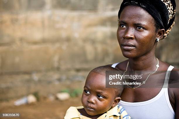 an african woman carrying her baby boy - liberian culture stock pictures, royalty-free photos & images