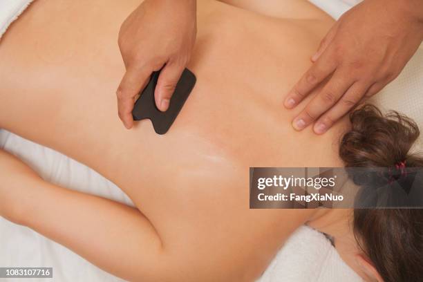 chinese doctor scrubbing patient's back - shiatsu stock pictures, royalty-free photos & images