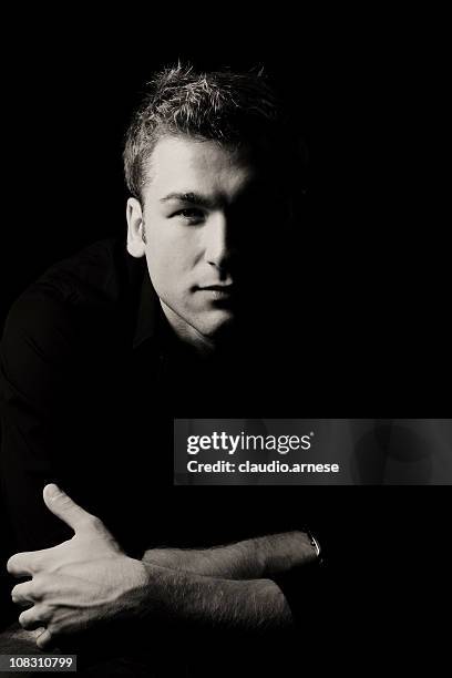 serius retrato de belleza masculina: fondo negro - clave baja fotografías e imágenes de stock