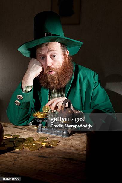 sad leprechaun count coins - leprechaun and pot of gold stock pictures, royalty-free photos & images