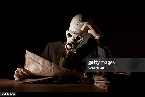 reading the news with a gas mask - deadly exchange stock pictures, royalty-free photos & images