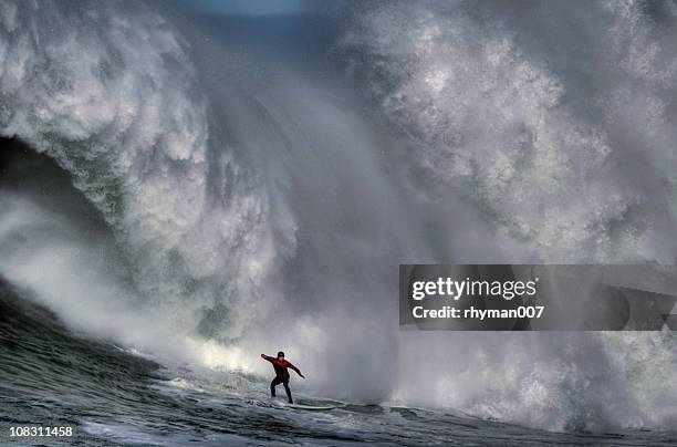 surfer at the bottom of a huge crashing wave  - extreme sport stock pictures, royalty-free photos & images