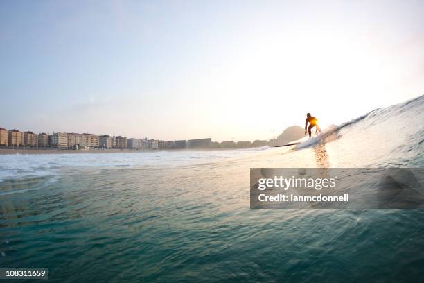 surfer bei sonnenuntergang - san sebastián spanien stock-fotos und bilder