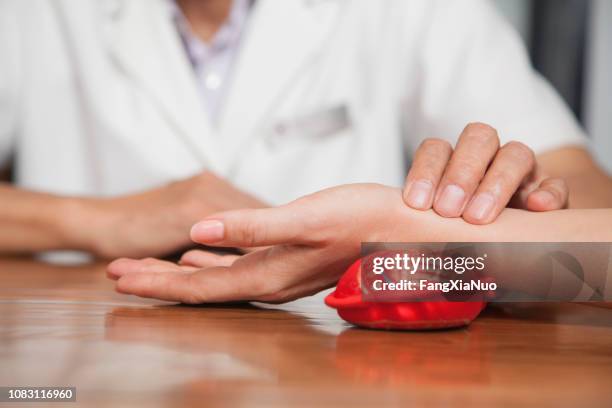 close up of man checking woman's pulse - chinese herbal medicine stock pictures, royalty-free photos & images