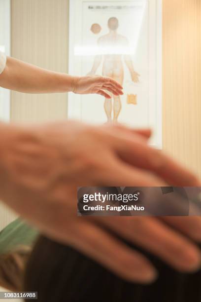doctor's hands hovering over patient - qi yang stock pictures, royalty-free photos & images