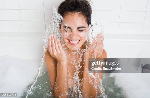 nettoyage et éclabousser sur le visage - beautiful woman bath photos et images de collection