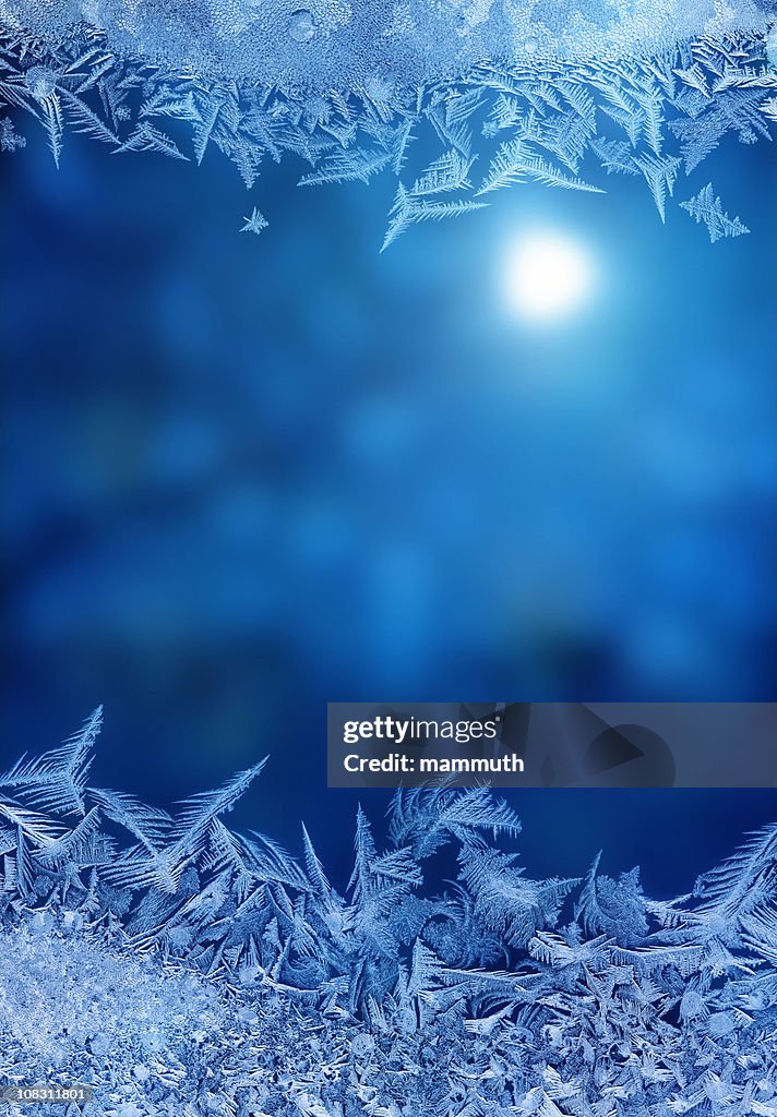 Winter night behind frozen window glass