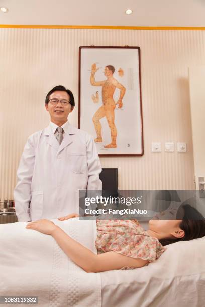 chinese doctor using acupuncture on patient - acupuncture elderly stock pictures, royalty-free photos & images