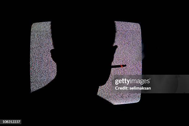 silhouette of man smoking cigarette and watching television in dark - tv addict stock pictures, royalty-free photos & images