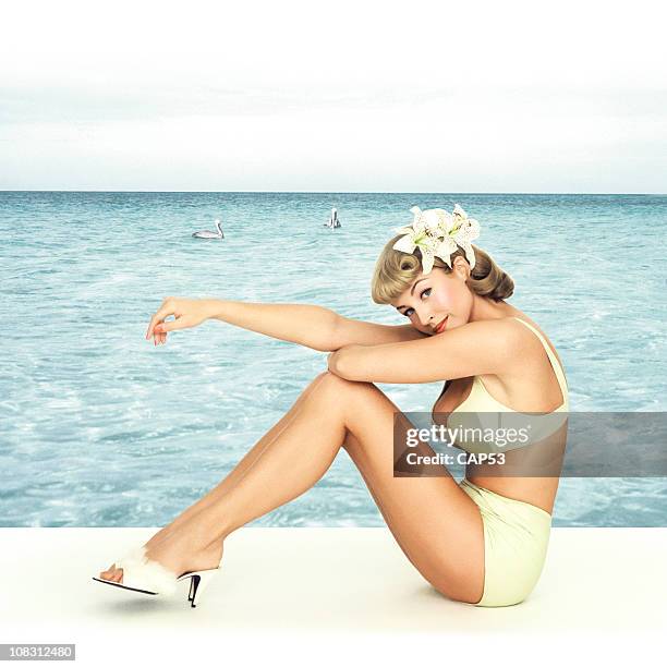 vintage chica pin-up sentado en frente de fondo al mar - pin up fotografías e imágenes de stock