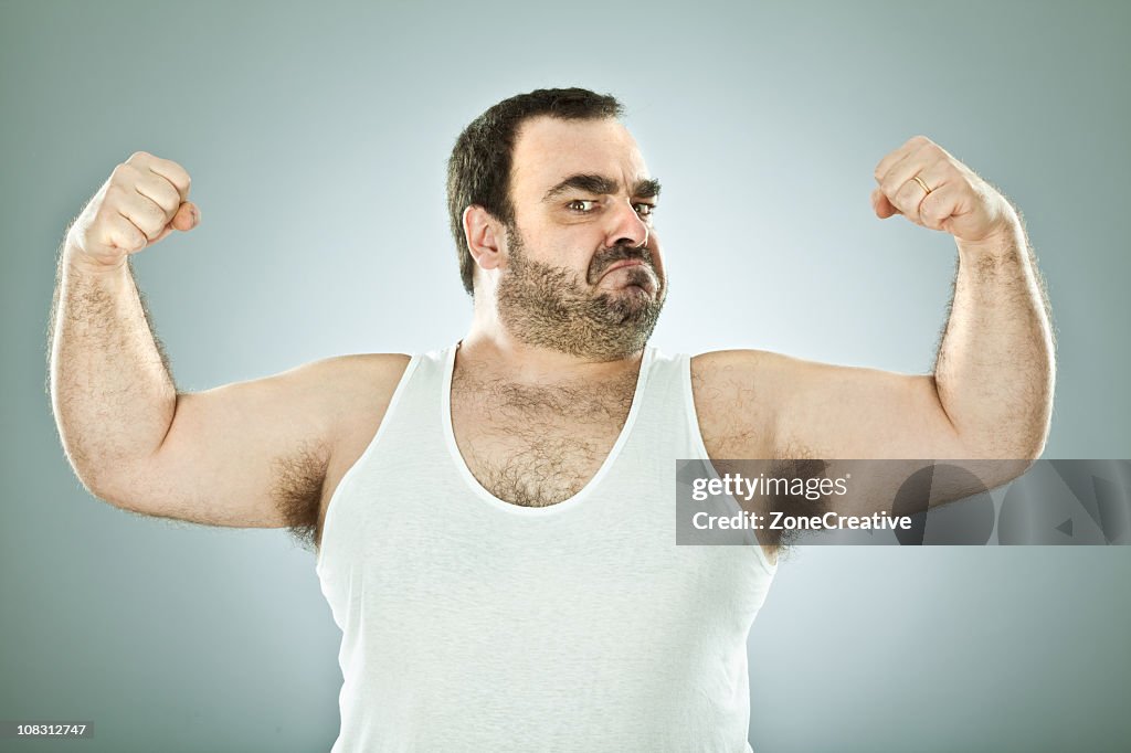 Stocky, hairy man flexing his arm muscles