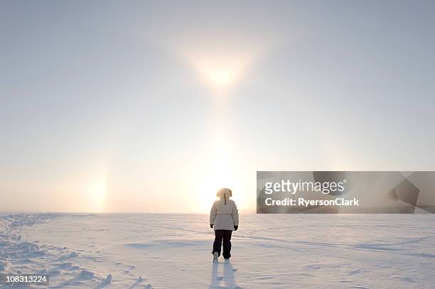 arctic sundogs or parhelion with woman in parka. - north stock pictures, royalty-free photos & images
