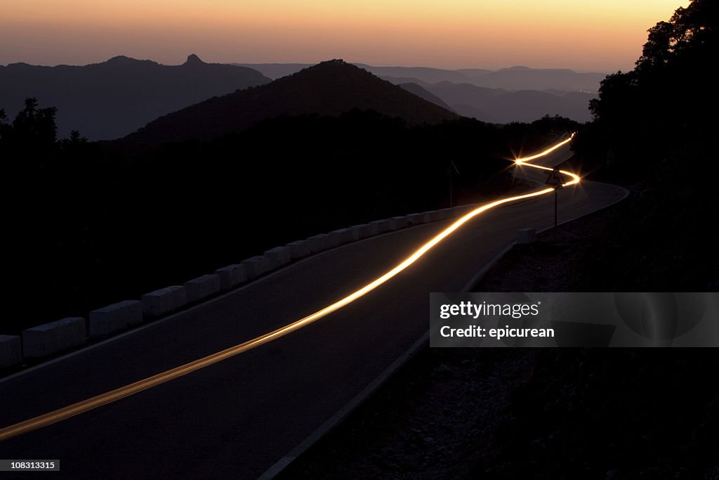 Sunset on a winding highway through the mountains