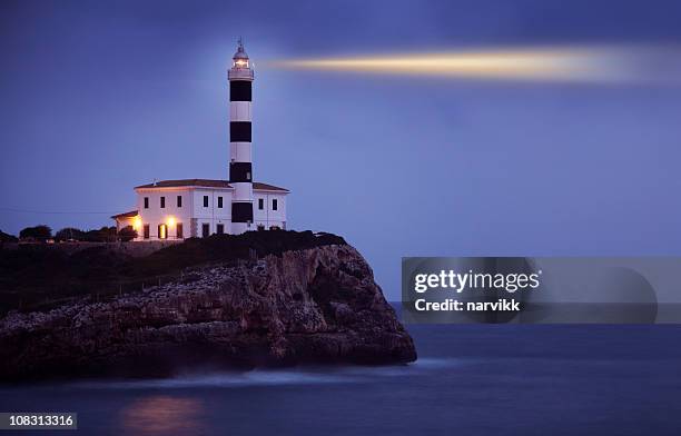 brillante faro en el acantilado en la noche - lighthouse fotografías e imágenes de stock