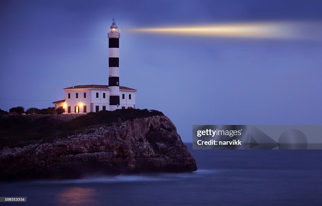 Shining Lighthouse on the Cliff by Night