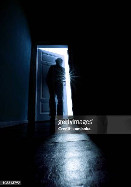 person opening a door from a dark room into the light - escaping home stock pictures, royalty-free photos & images