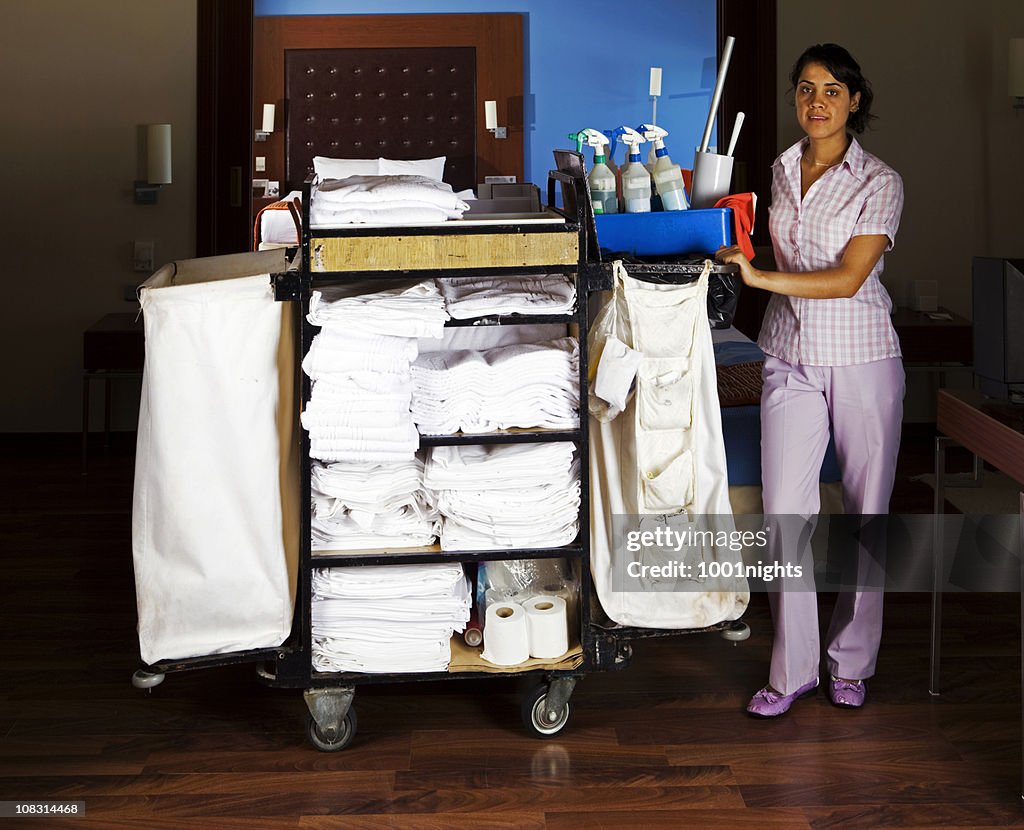 Giovane cameriera pulizia della suite di hotel