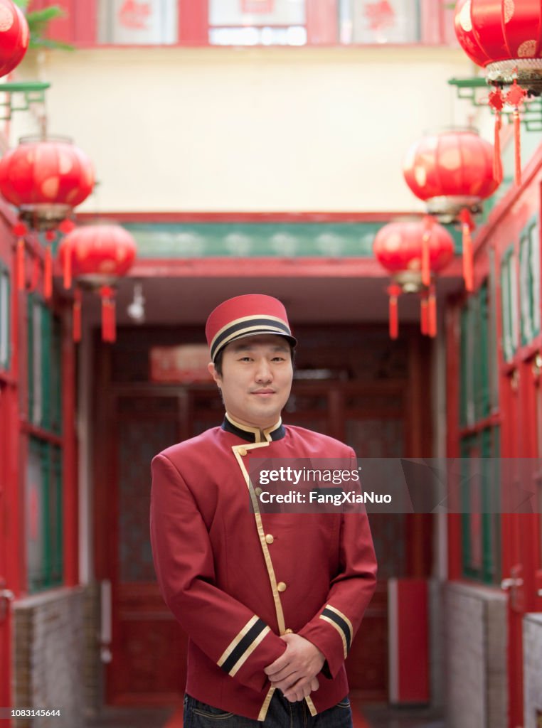 Chinese bellhop standing in hotel