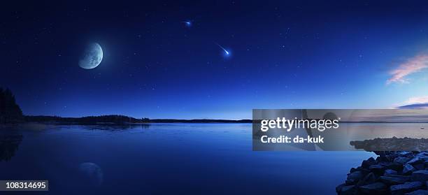 rising moon over lake - shooting star stock pictures, royalty-free photos & images