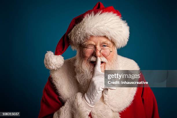 pictures of real santa claus with fingers on lips - santa clause stock pictures, royalty-free photos & images