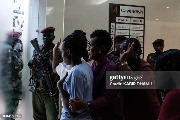 People wait to be evacuated after a bomb blast from the office block attached to DusitD2 hotel in Nairobi, Kenya, on January 15, 2019. - A huge blast...