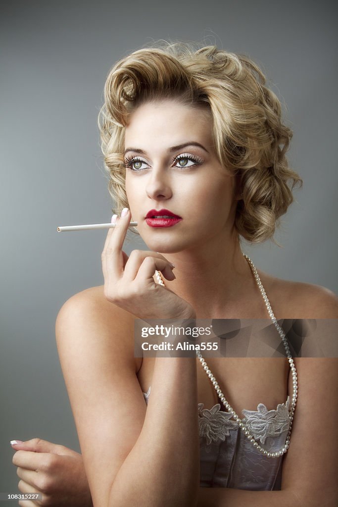 Retro glamor portrait of young beautiful blond woman with cigarette