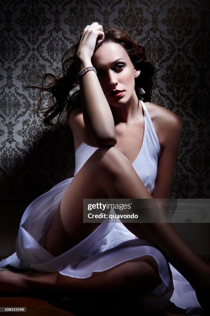 Bela jovem sentada na sombra com vestido branco, Copyspace