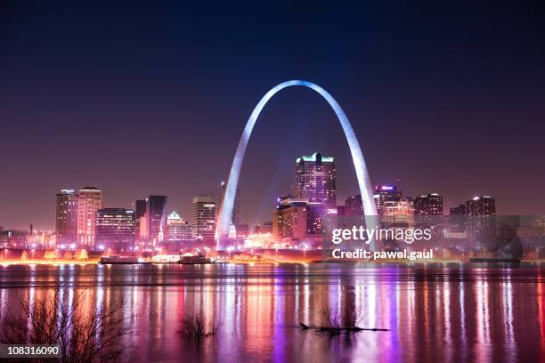 skyline of saint louis with gateway arch by night - st louis missouri stock pictures, royalty-free photos & images