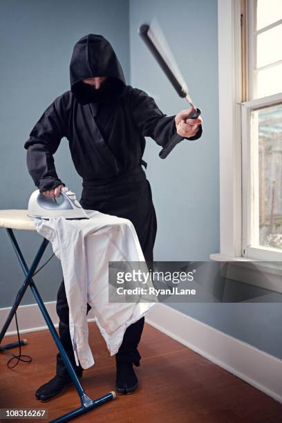 domestic ninja bügelbrett mit nunchaku - albert krieger stock-fotos und bilder