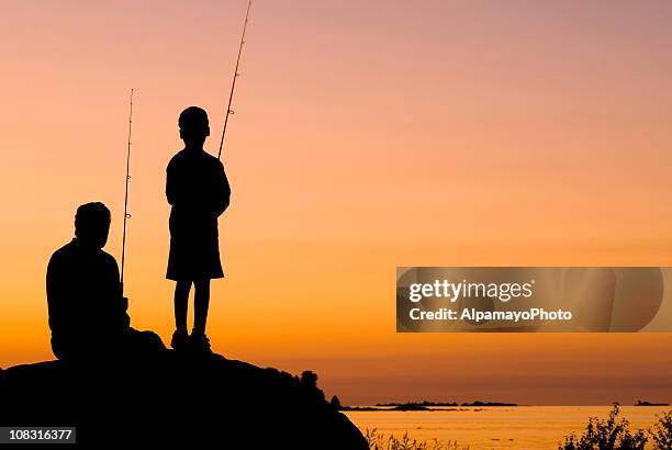 kleine junge und sein großvater angeln bei sonnenuntergang-i - grandfather silhouette stock-fotos und bilder