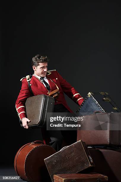 bell ragazzo tirando un pesante trunk in hotel. - bellhop foto e immagini stock