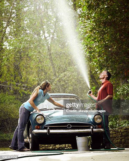 couple washing vintage car - oldtimerauto stockfoto's en -beelden