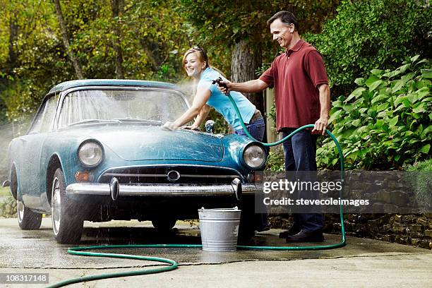 couple washing vintage car - oldtimerauto stockfoto's en -beelden