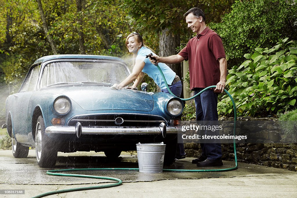 Couple Washing Vintage Car