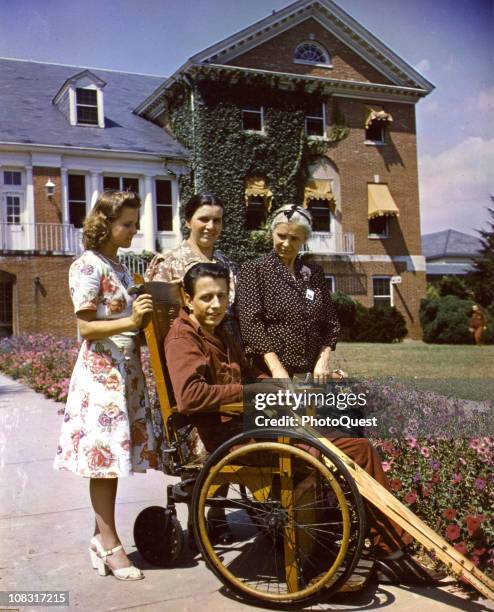 Patient in a wheelchair is shown with his visiting family at Walter Reed General Hospital, in Washington, DC, 1945.