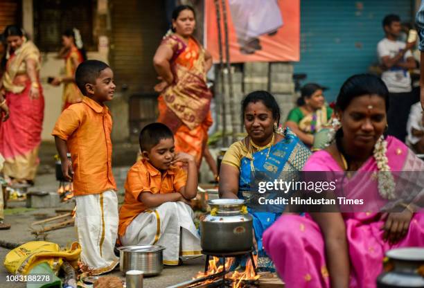 Hindu devotees cook traditional sweet dish on open fires during a community function on the occasion of Pongal at Dharavi on January 15, 2019 in...