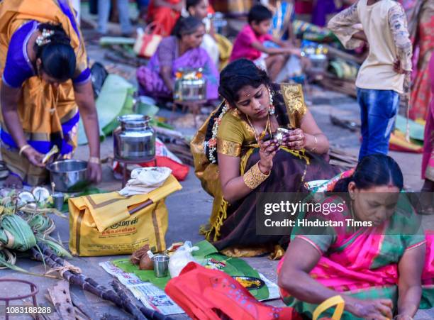 Hindu devotees cook traditional sweet dish on open fires during a community function on the occasion of Pongal at Dharavi on January 15, 2019 in...