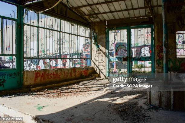 Building destroyed by Israeli raids and bombs seen next to the Separation Wall. The Israeli Separation Wall is a dividing barrier that separates the...