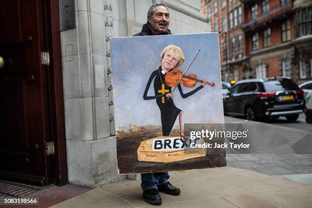 Political artist Kaya Mar stands with his painting depicting Prime Minister Theresa May playing a violin outside Millbank Studios in Westminster on...