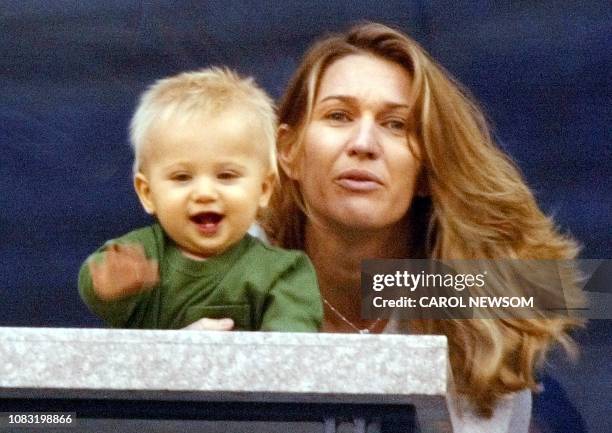 Steffi Graf holds her son Jaden Gil as they watch husband and father Andre Agassi's match against Justin Gimelstob 29 August, 2002 at the US Open in...