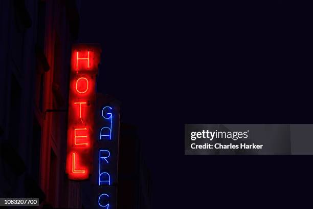 vintage neon hotel and garage signs at night - downtown neon stock-fotos und bilder