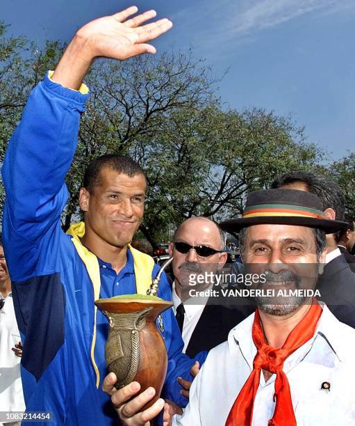 Brazilian soccer player Rivaldo , waves while a man dressed as a Gaucho offers him a drink in Porto Alegre, Brazil on 14 August 2001. Brazil will...