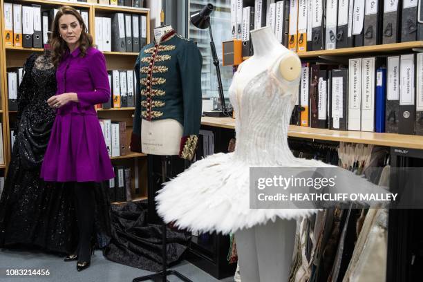 Britain's Catherine, Duchess of Cambridge, looks at a costume in the pattern room during a visit to the costume department at the Royal Opera House...