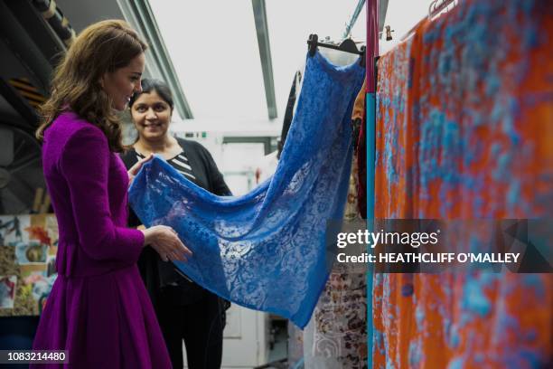 Britain's Catherine, Duchess of Cambridge, looks at a costume with head of dye dept Parveen Banga during a visit to the costume department at the...