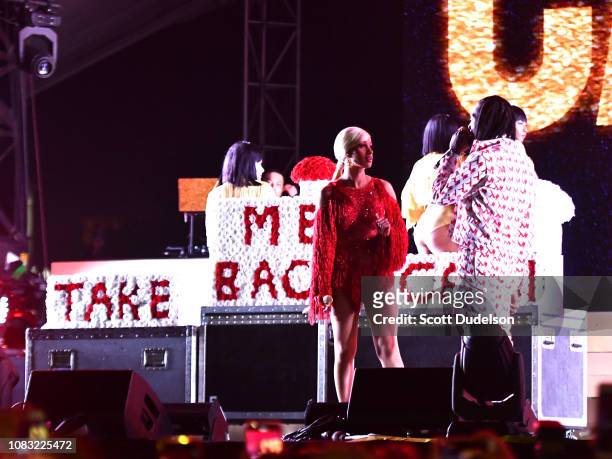 Singer Cardi B is presented a 'Take Me Back' card onstage by Offset during day 2 of the Rolling Loud Festival at Banc of California Stadium on...